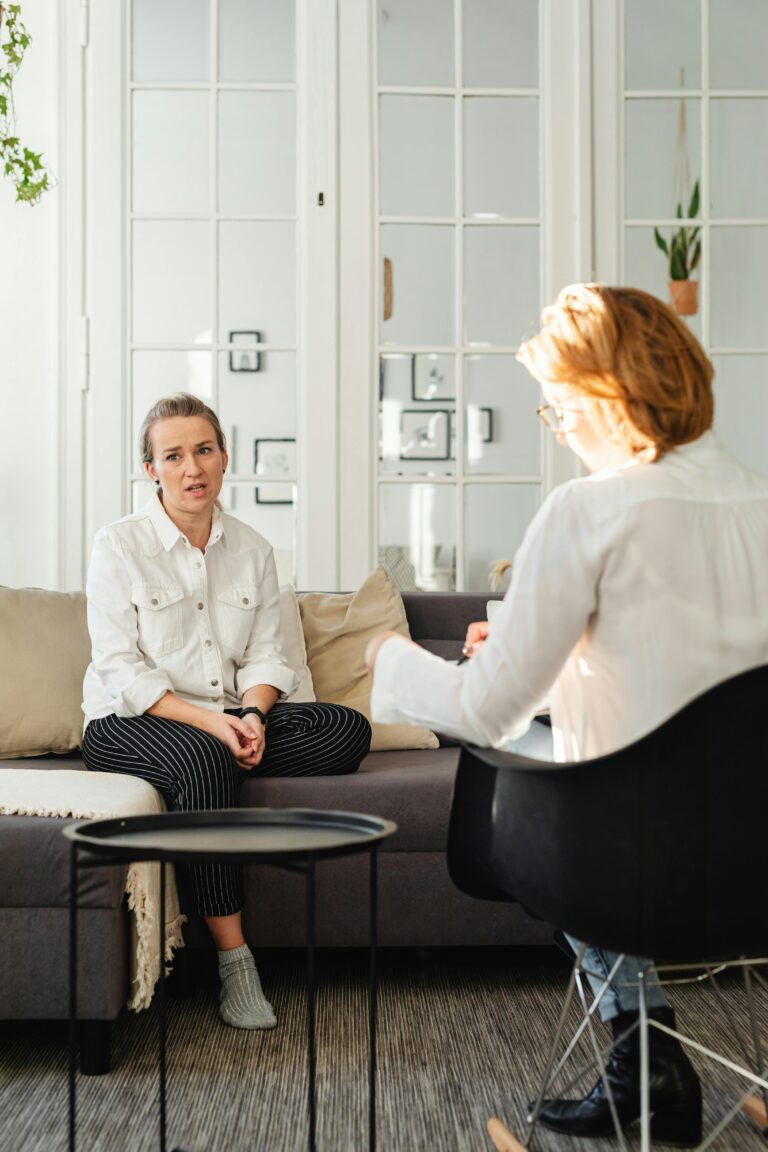 A woman in therapy, engaged in discussion with a professional therapist.